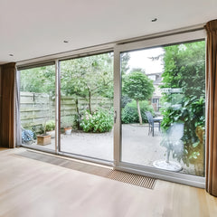 12 Foot Wide Aluminum Panoramic Sliding Door 3-Panel overlooking a lush garden and patio area.