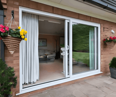 6 Foot Wide Sliding 2-Panel Panoramic Door (Multiple Heights) with elegant curtains and hanging flower pots.