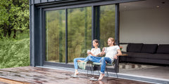 Couple enjoying drinks by the 8 Foot Wide Sliding 2-Panel Panoramic Door (Multiple Heights) in a modern home setting.