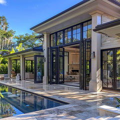 Exterior view of a modern home with 20' bi-fold panoramic doors opening to a pool area, showcasing style and elegance.